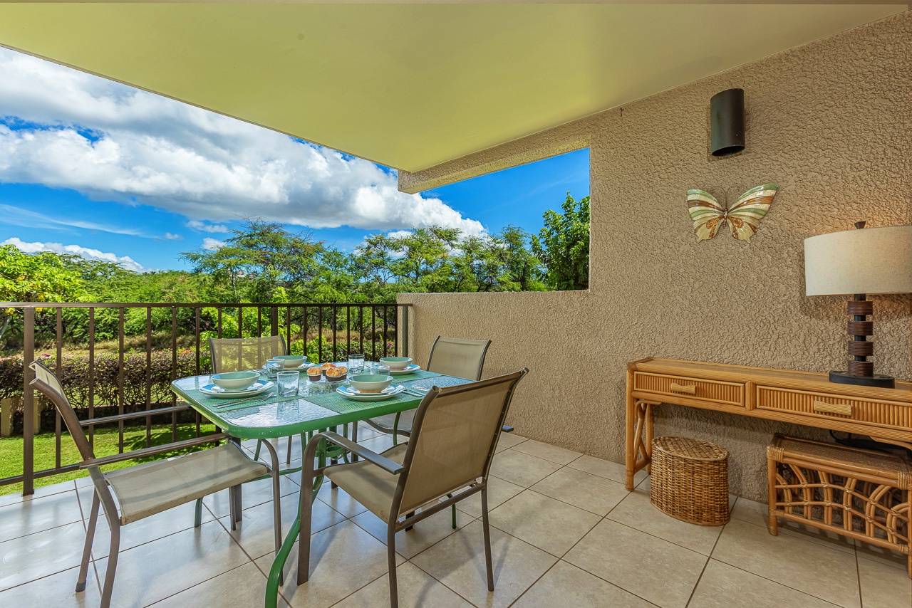 Enjoy your morning coffee or evening meals at this inviting covered terrace, where lush greenery stretches across the horizon beneath endless sky. The dining setup and charming décor create your perfect outdoor retreat.