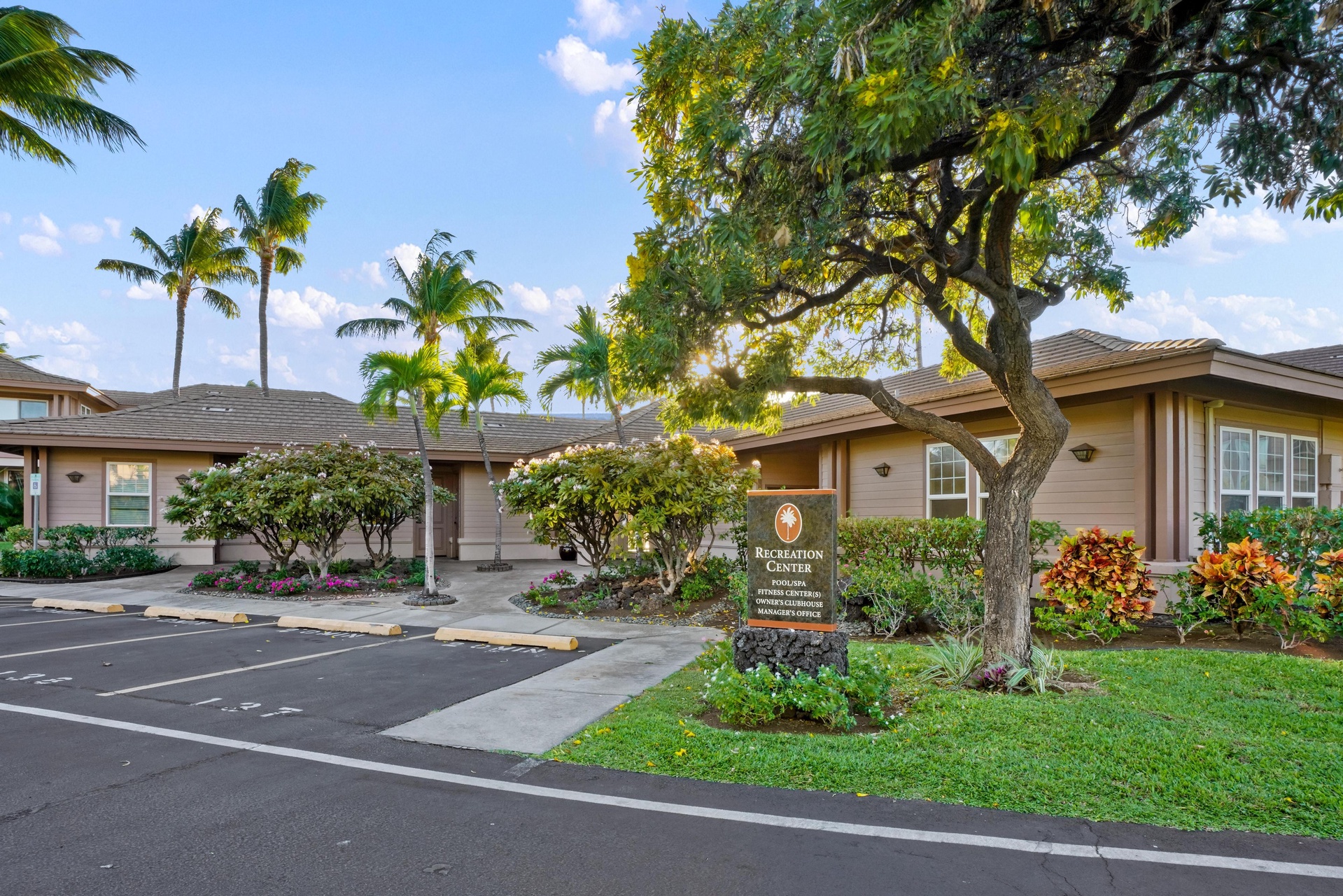 Resort recreation center surrounded by tropical landscaping and palm trees offers on-site amenities during your Hawaiian getaway.