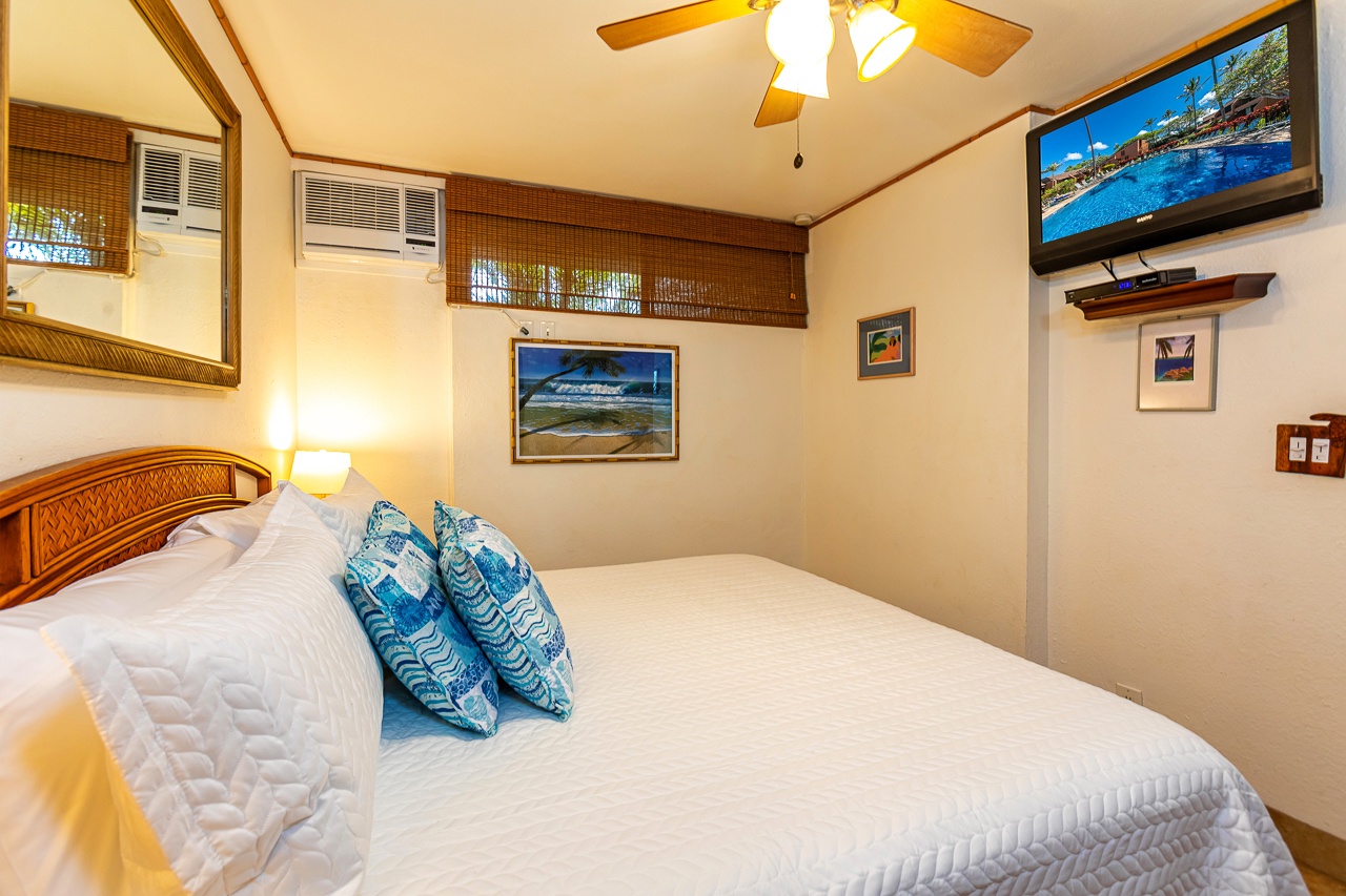 Unwind in your cozy bedroom with tropical island vibes, where crisp linens, a ceiling fan, and AC keep you comfortable after a day at the beach.