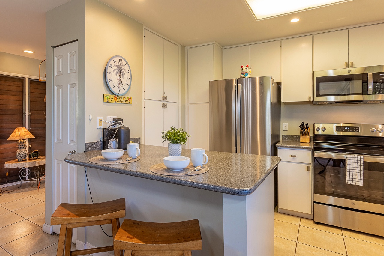 Your well-equipped kitchen awaits, featuring stainless steel appliances, ample cabinet space, and a breakfast bar perfect for morning coffee or casual meals together.
