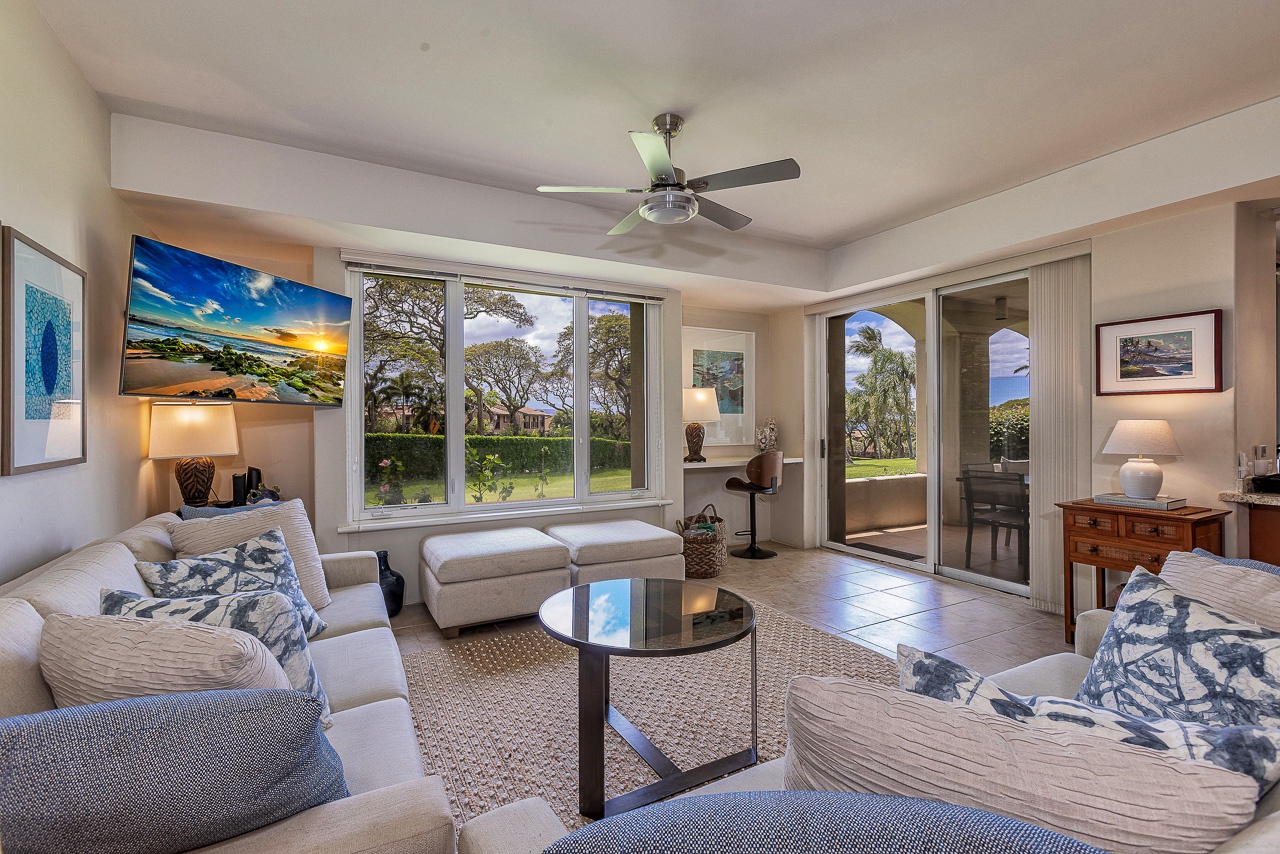 Unwind in your bright, airy living room with plush seating, a ceiling fan, and peaceful garden views—your perfect retreat after a day of exploring.
