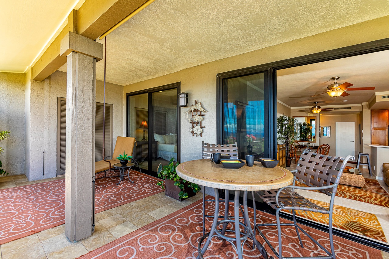 Your private balcony invites morning coffee and sunset views, with a cozy table for two overlooking the inviting living space beyond sliding doors.