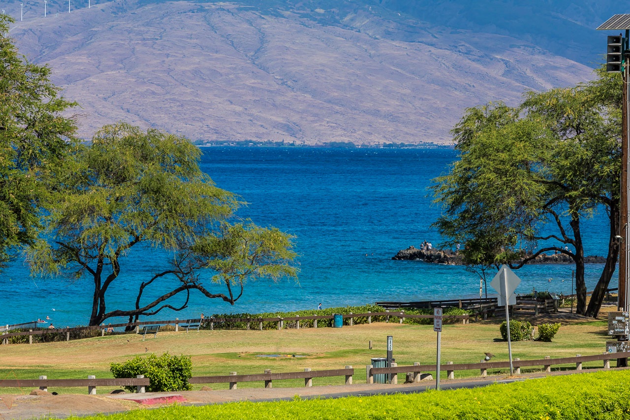 This beachfront property offers direct access to pristine turquoise waters backed by dramatic mountain scenery, with expansive lawns and shaded pathways perfect for outdoor relaxation.