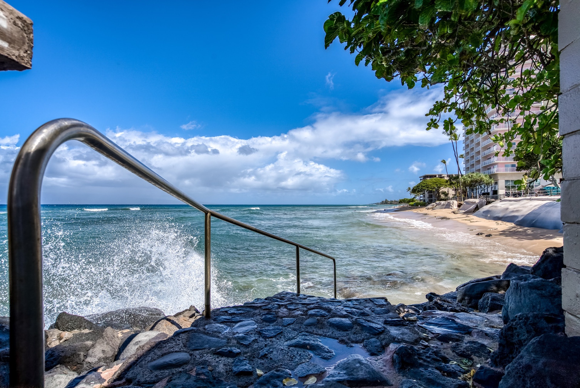 The property sits right where turquoise waves meet the shore, offering direct beach access and stunning coastal views along the waterfront promenade.