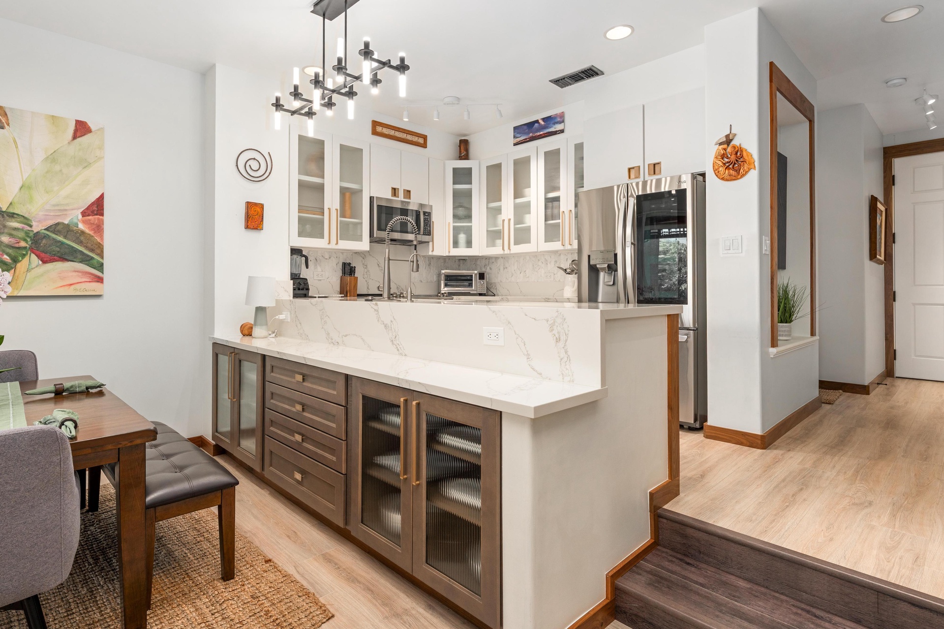 Your gourmet kitchen features sleek white cabinets, marble countertops, and modern appliances perfect for preparing memorable meals during your stay.