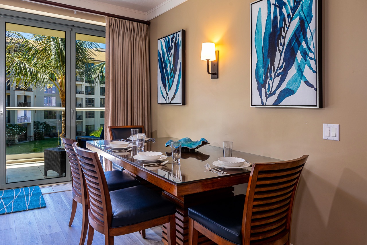 Step into your inviting dining space, where warm lighting and tropical breezes from your private patio create the perfect setting for memorable meals with loved ones.