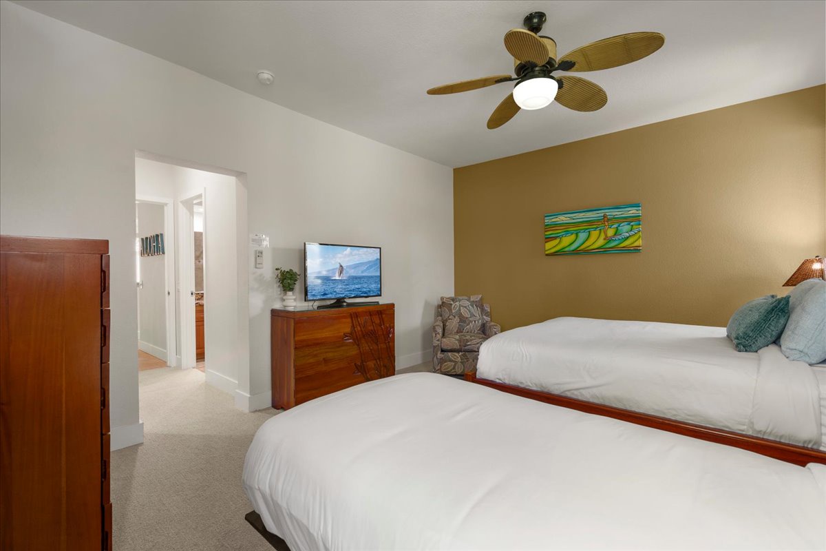 Relax in your coastal retreat with two plush beds, tropical ceiling fan, and surf-themed art that sets the perfect beach vibe for your stay.