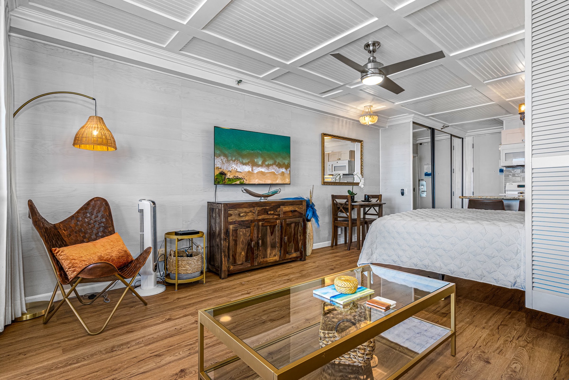 Step into your stylish open-plan studio where coastal charm meets modern comfort. Warm wood floors and beachy décor create a relaxing vibe, while the airy ceiling fan and cozy seating invite you to unwind after a day of exploration.