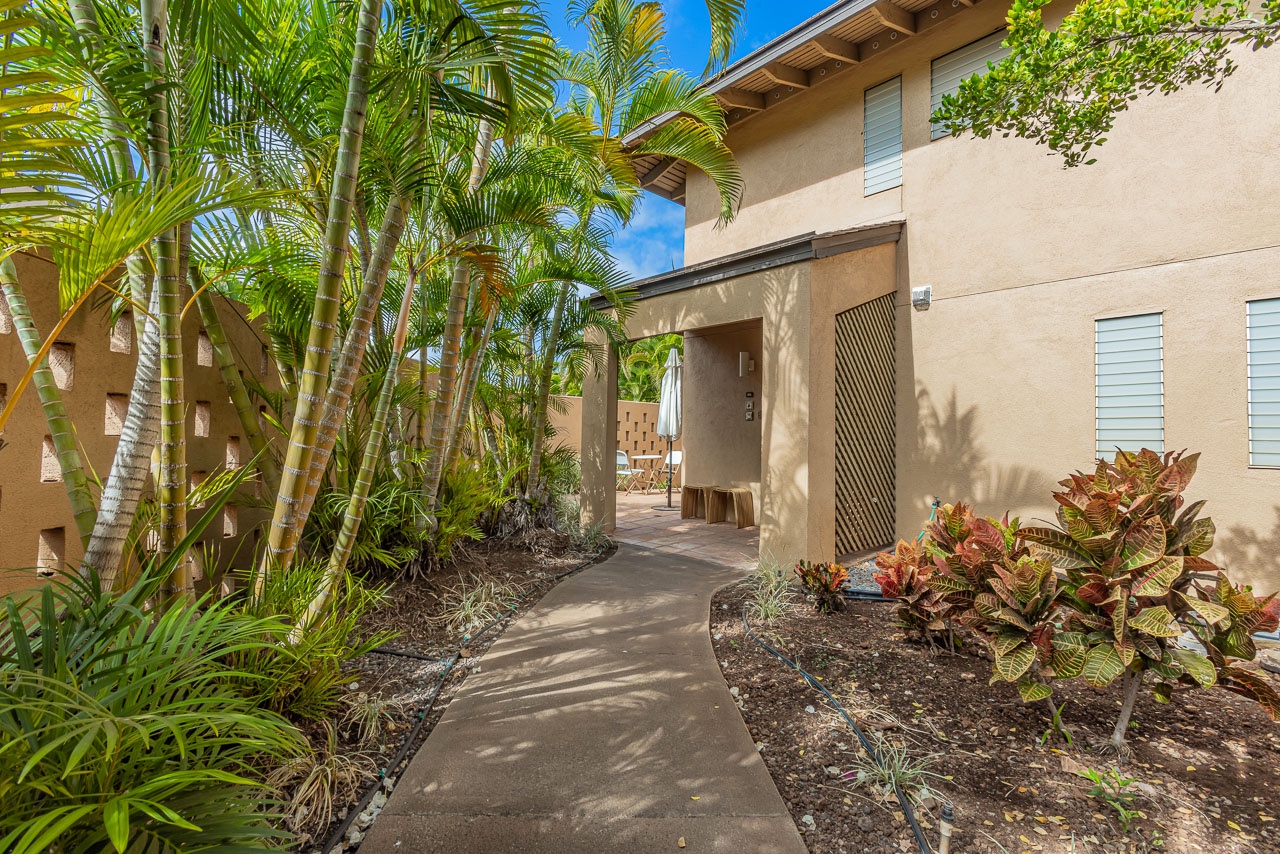 Lush landscaping frames the walkway to the condo entrance