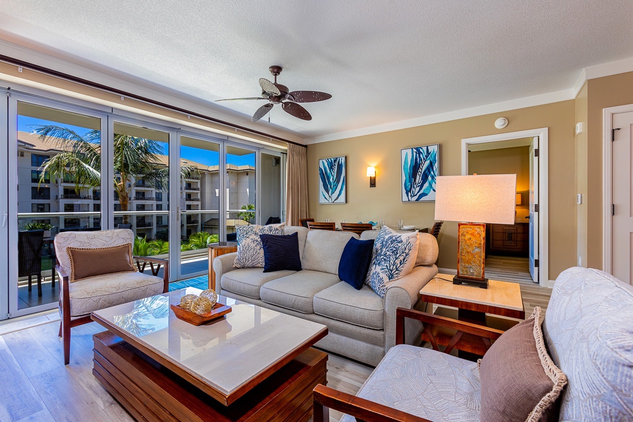 Sink into plush seating as tropical breezes flow through open glass doors, bringing your private balcony and outdoor dining space right into your inviting living room.