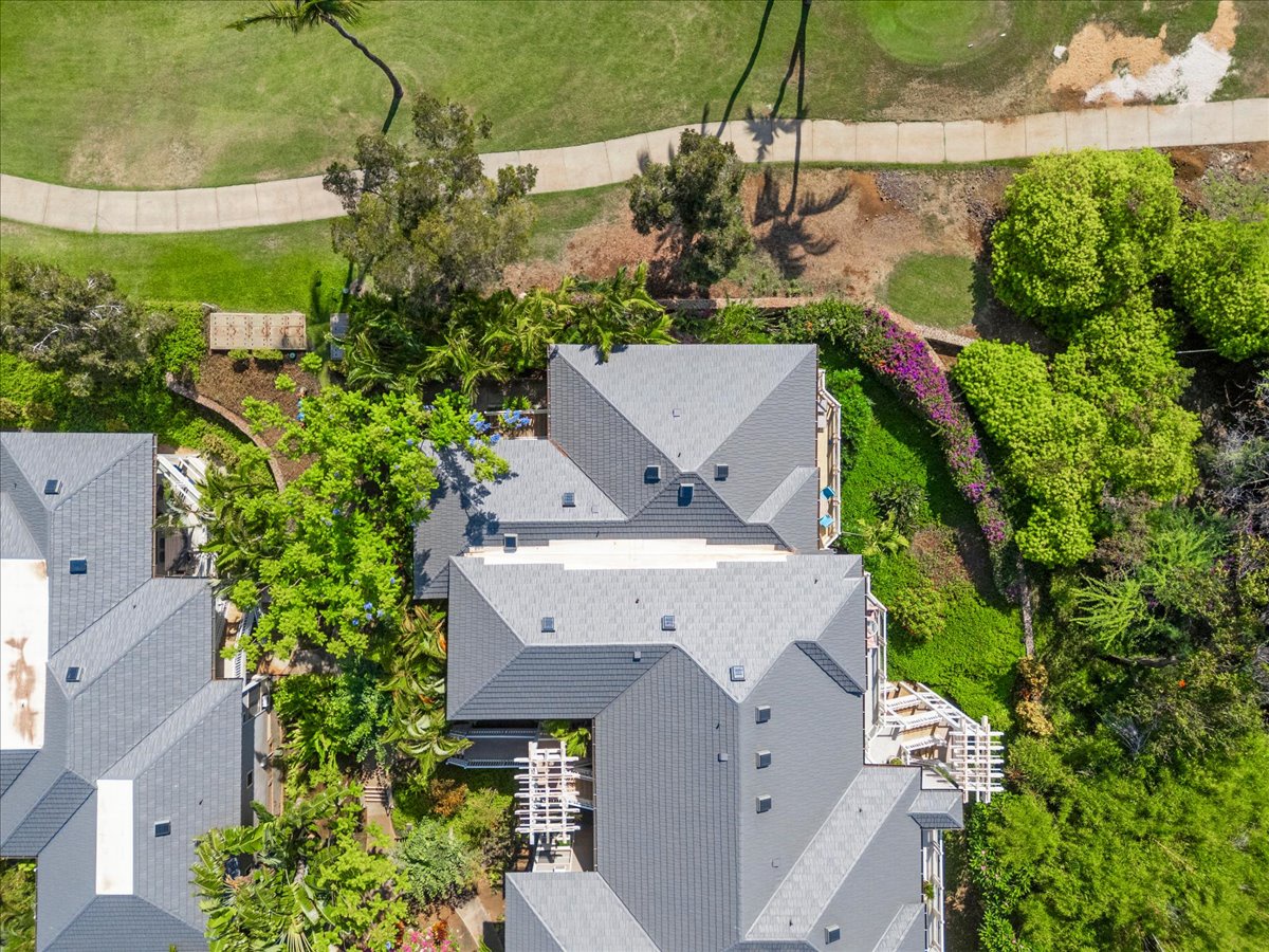Aerial view showcasing the property nestled in a lush, landscaped neighborhood with manicured lawns, mature trees, and tranquil surroundings visible from above.