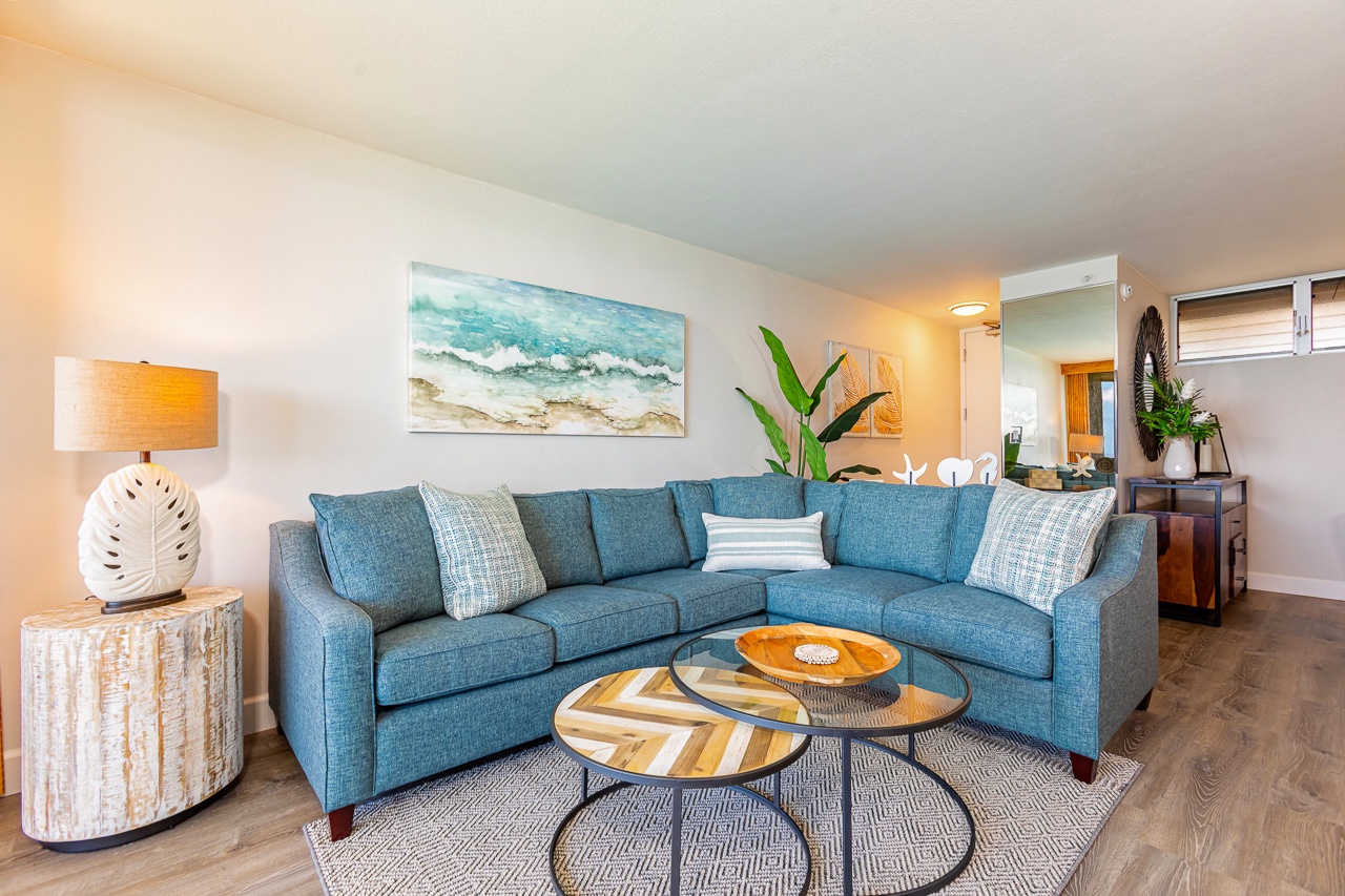 Your bright coastal living space features a plush sectional perfect for relaxing after a day of adventure. Ocean-inspired decor and lush greenery create a calming retreat where you can unwind with loved ones.