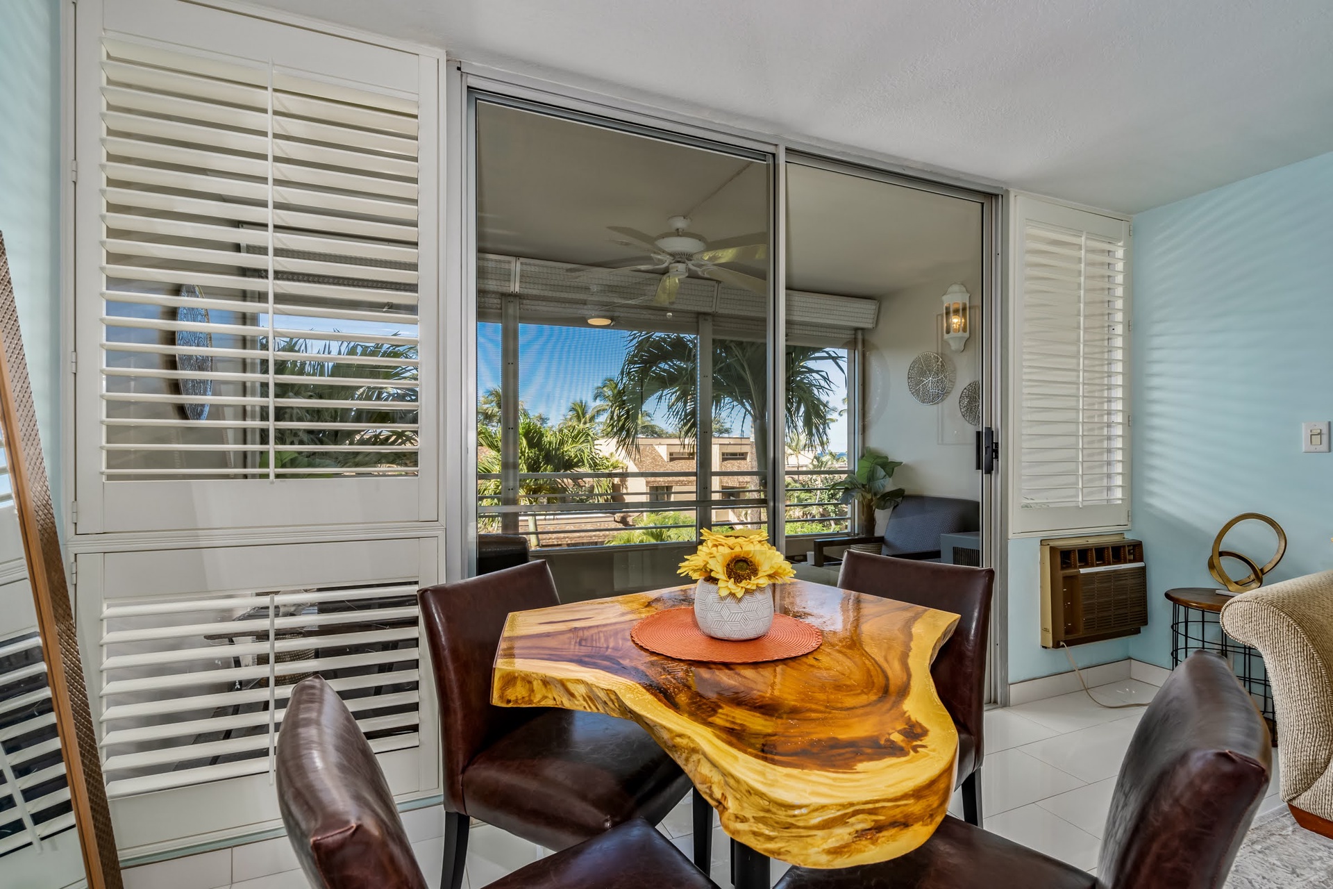 Step onto your private balcony where morning coffee meets tropical breezes. The sunflower centerpiece welcomes you to a cozy dining nook with views of swaying palms and sunshine.