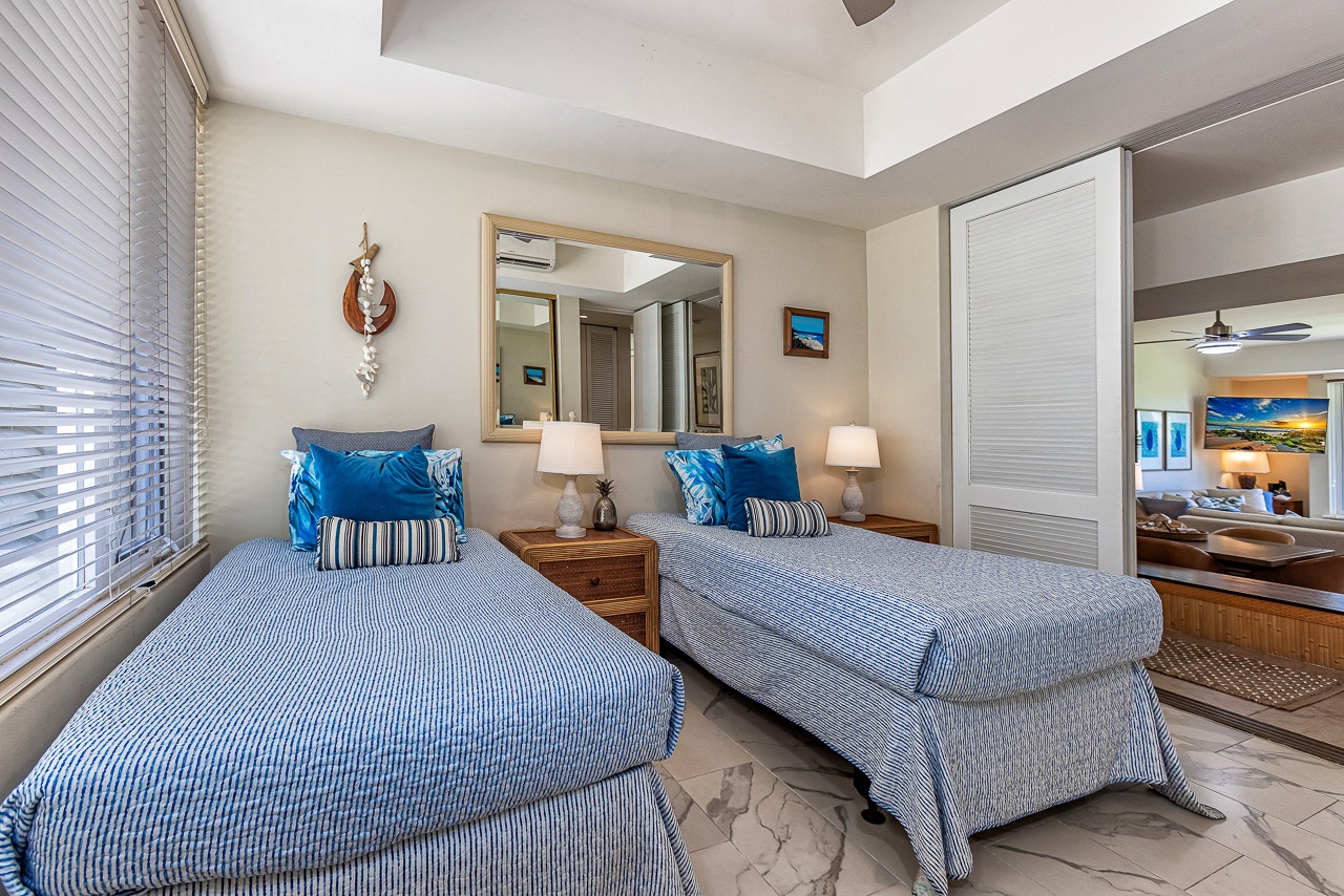 Sink into soft, coastal-styled twin beds with crisp linens and plush pillows, surrounded by warm island art and gentle natural light through your blinds.