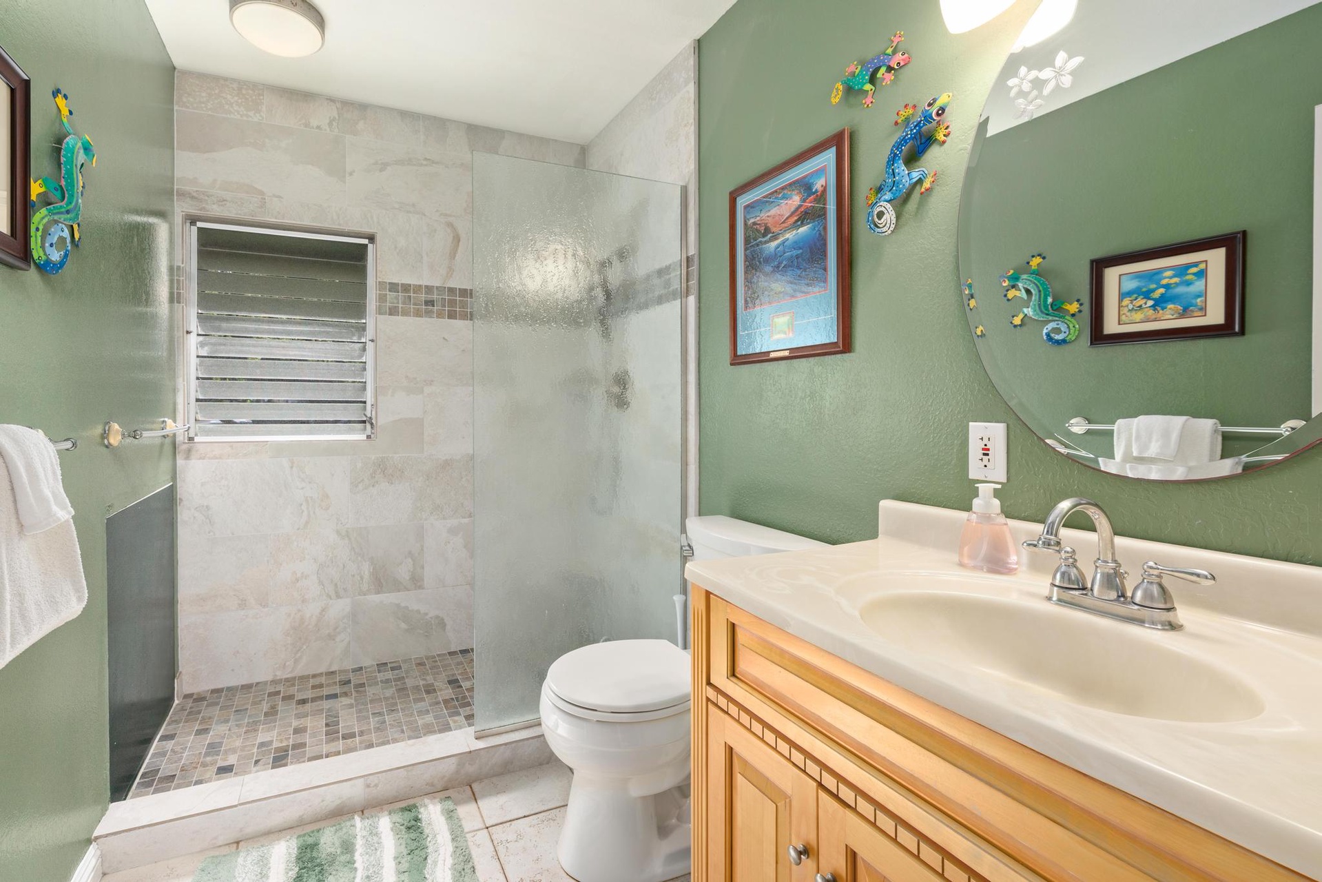 The guest bathroom features a walk-in shower with ocean-themed decor and tropical touches that bring island vibes to your daily routine.