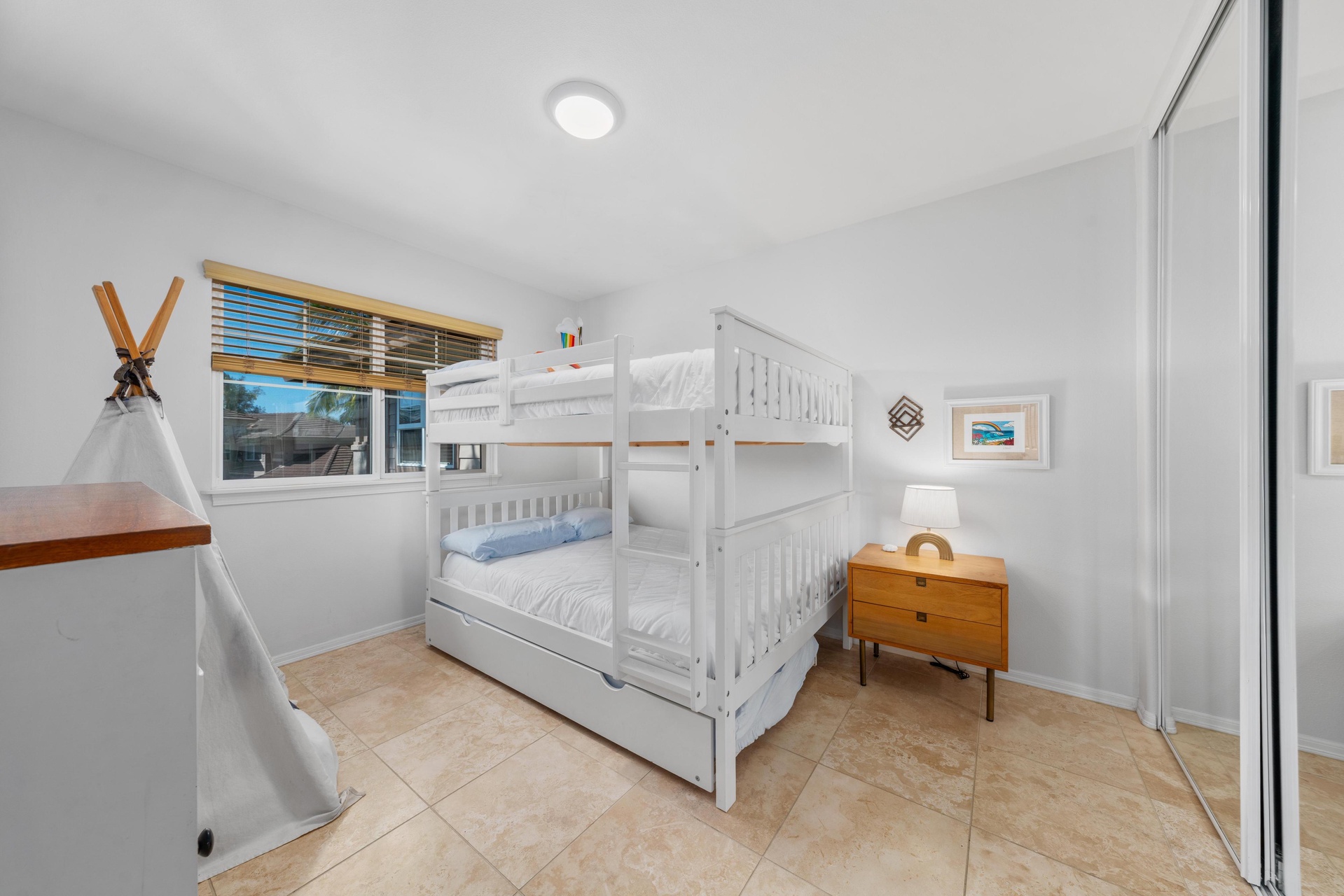 Your children will love this playful bedroom with white bunk beds, a charming teepee, and cozy touches that make bedtime an adventure.