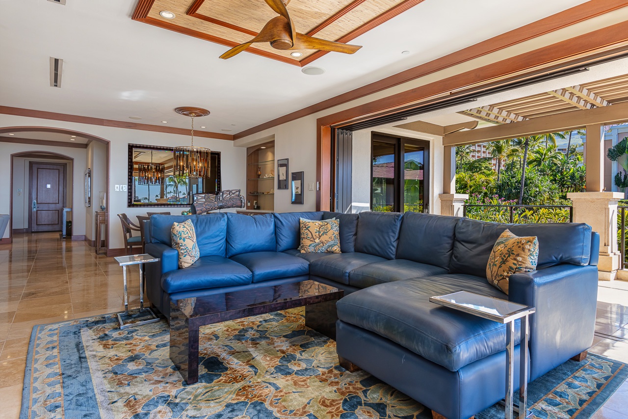 Sink into spacious comfort as you take in the tropical garden views through soaring glass doors. The vaulted ceiling and inviting blue sectional create your perfect retreat for relaxing after island adventures.