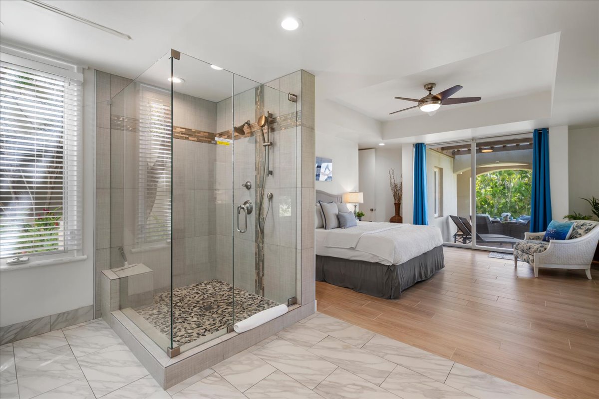 Step into your private retreat where a luxurious glass-enclosed shower and plush king bed await. Unwind in the spa-like atmosphere, then drift off under the gentle ceiling fan—your perfect escape.
