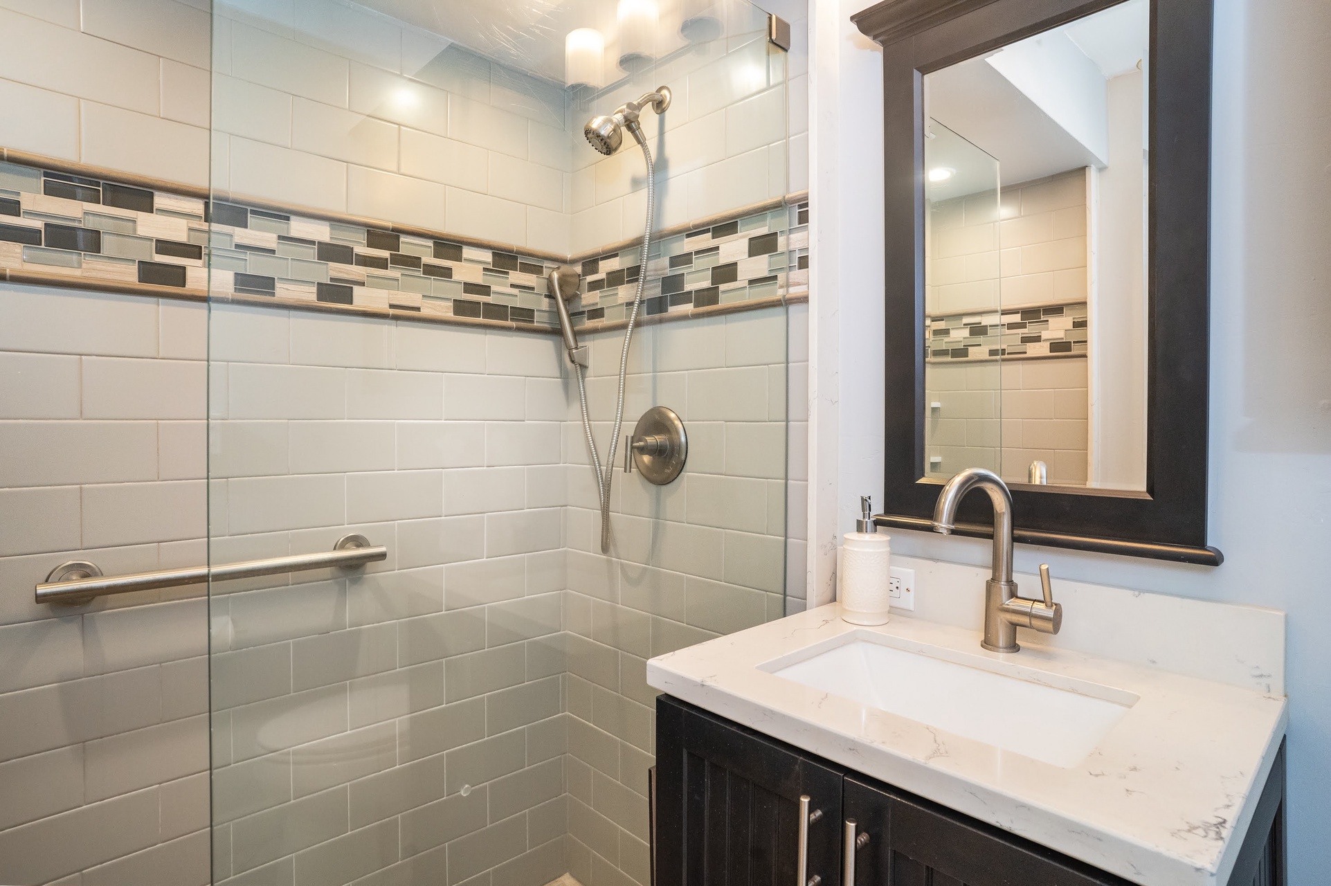 The bathroom features a convenient handheld showerhead.