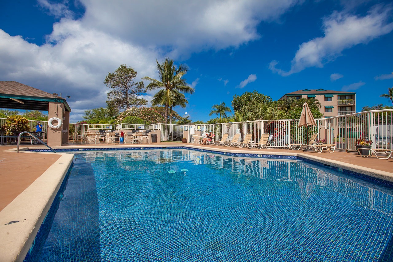 Sparkling pool area with tropical surroundings and comfortable loungers for your perfect poolside retreat.