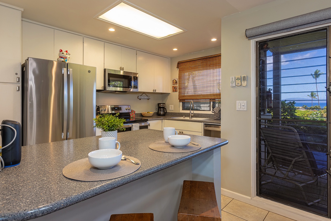 Your fully equipped kitchen opens to a balcony with ocean views, perfect for morning coffee while planning island adventures.