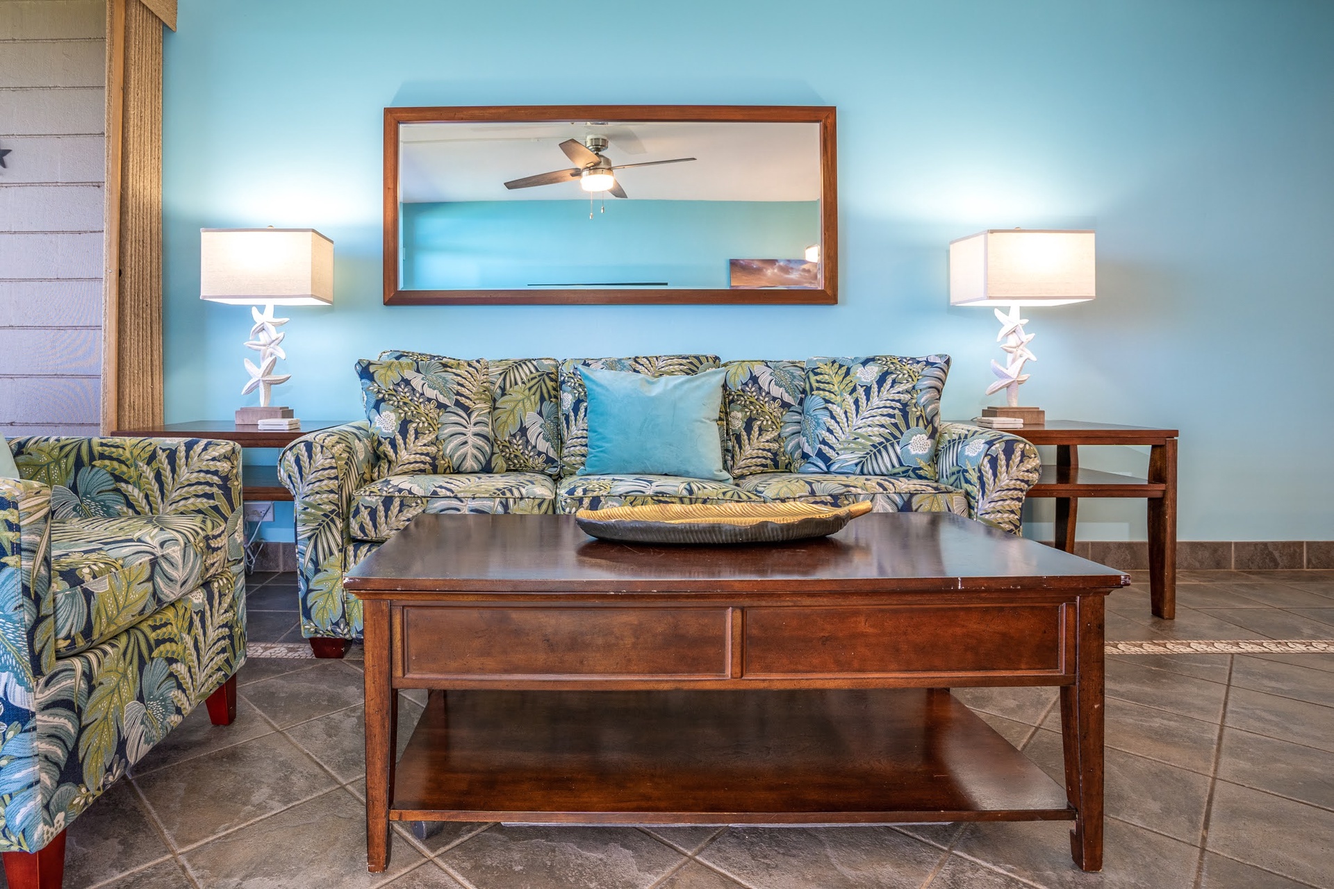 Sink into tropical-print seating and let the coastal blues and warm wood accents ease your mind. This inviting living room is your perfect spot for morning coffee or winding down after a day of adventure.