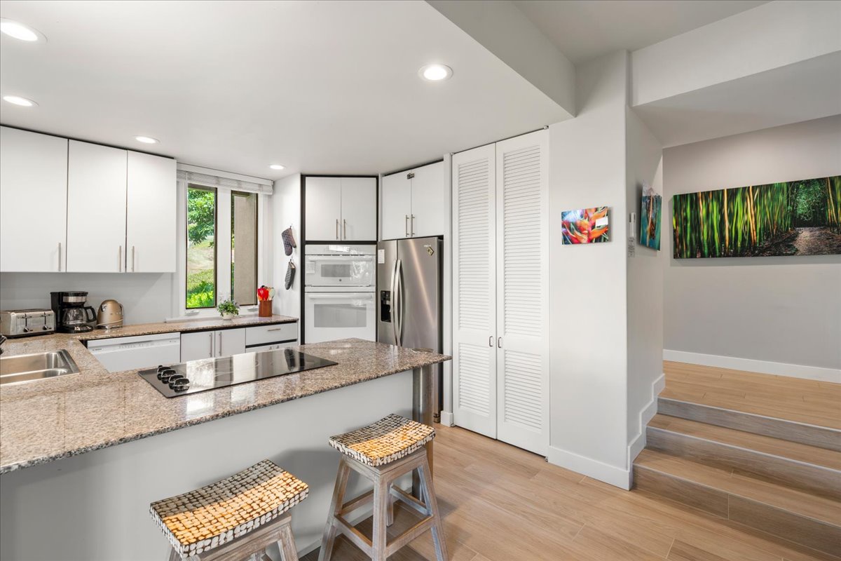 Your modern kitchen invites you to gather around the spacious island, where sleek granite countertops and high-end stainless steel appliances make meal prep a pleasure.
