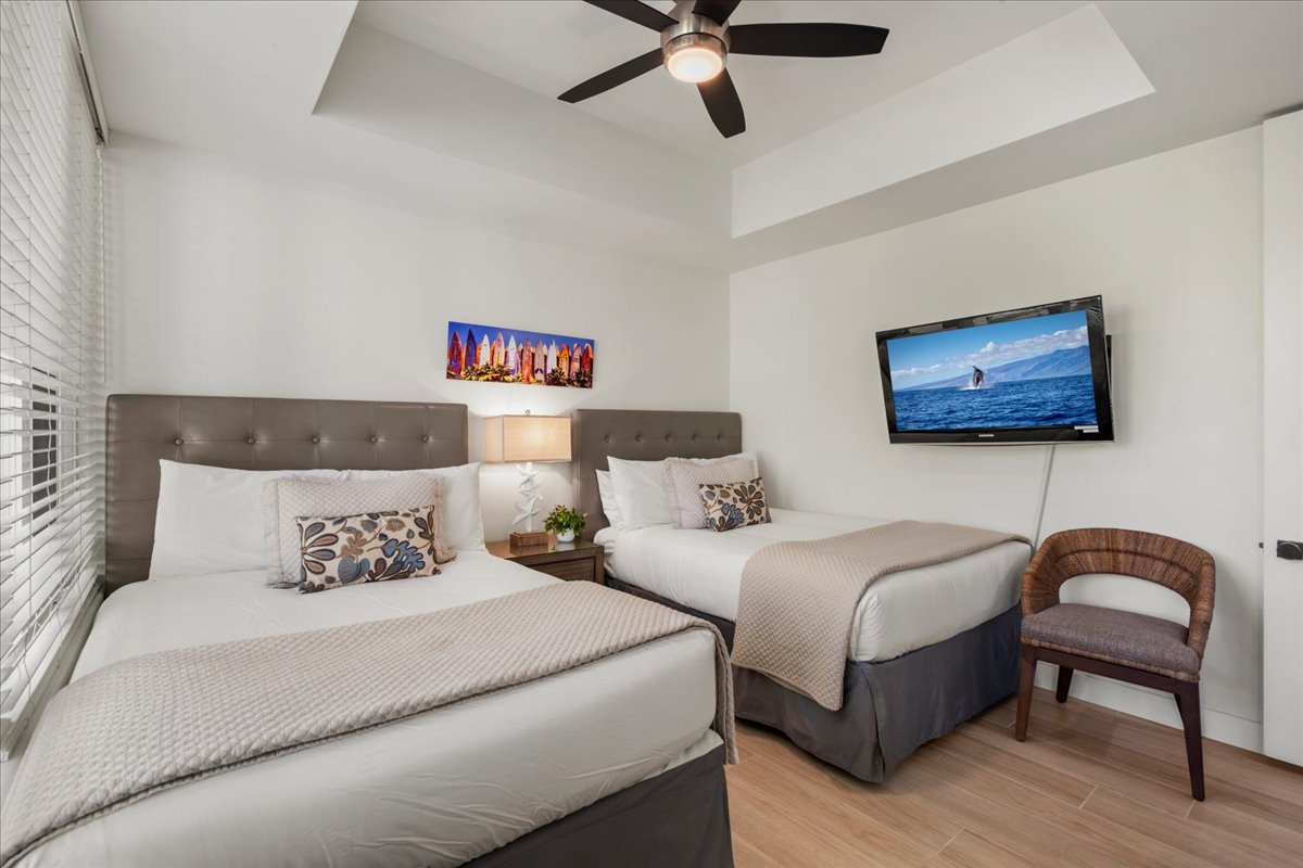 Step into your bright, modern bedroom where two plush beds await—perfect for restful nights after days spent exploring. The chic decor and coastal accents create a soothing retreat just for you.