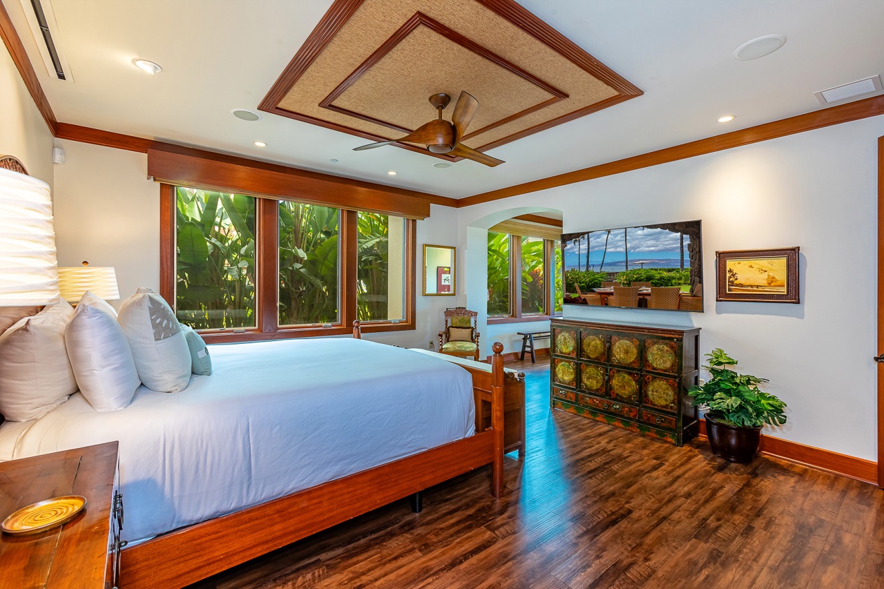 Wake up surrounded by lush tropical greenery through expansive windows that frame your private garden oasis. Rich wood accents and elegant ceiling details create a serene, resort-style sanctuary where relaxation comes naturally.