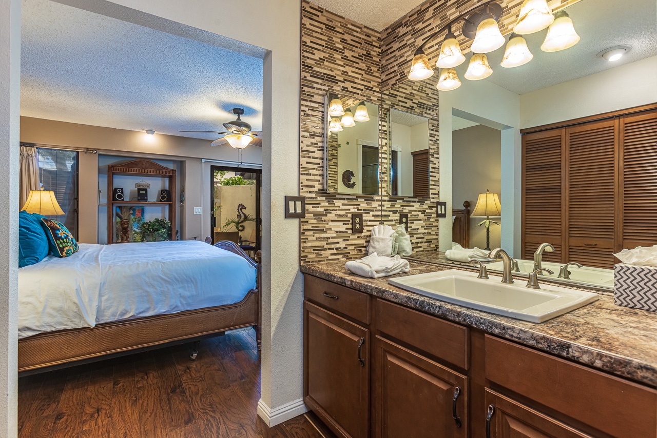 Your master suite features a stunning bathroom with elegant stone tile backsplash, and warm lighting for your evening routine.