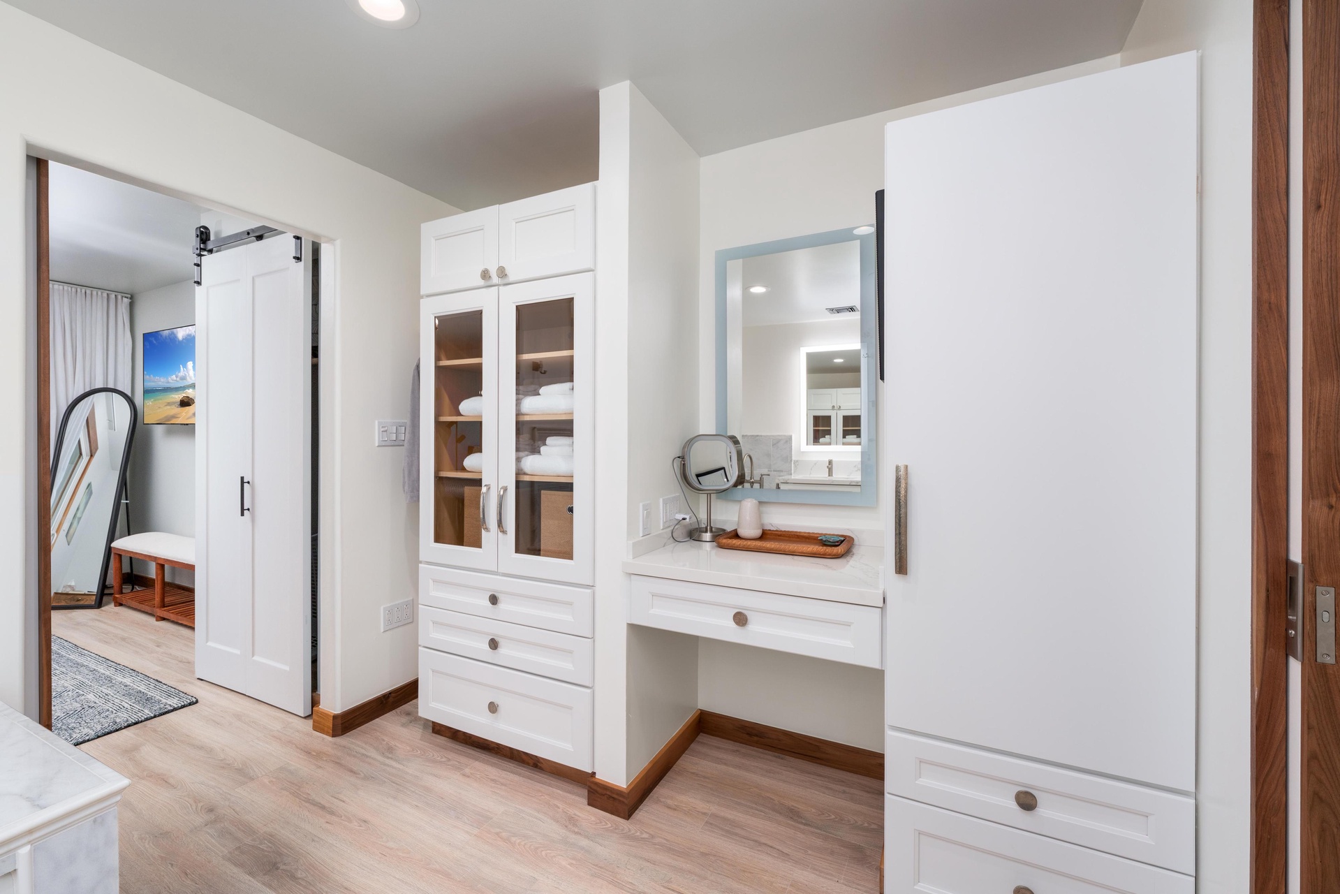 Your beautifully organized bedroom features custom white cabinetry with a built-in vanity and mirror, perfect for your morning routine.