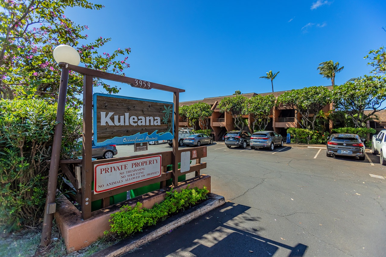 The Kuleana property entrance welcomes guests with tropical landscaping and convenient parking near the main building.