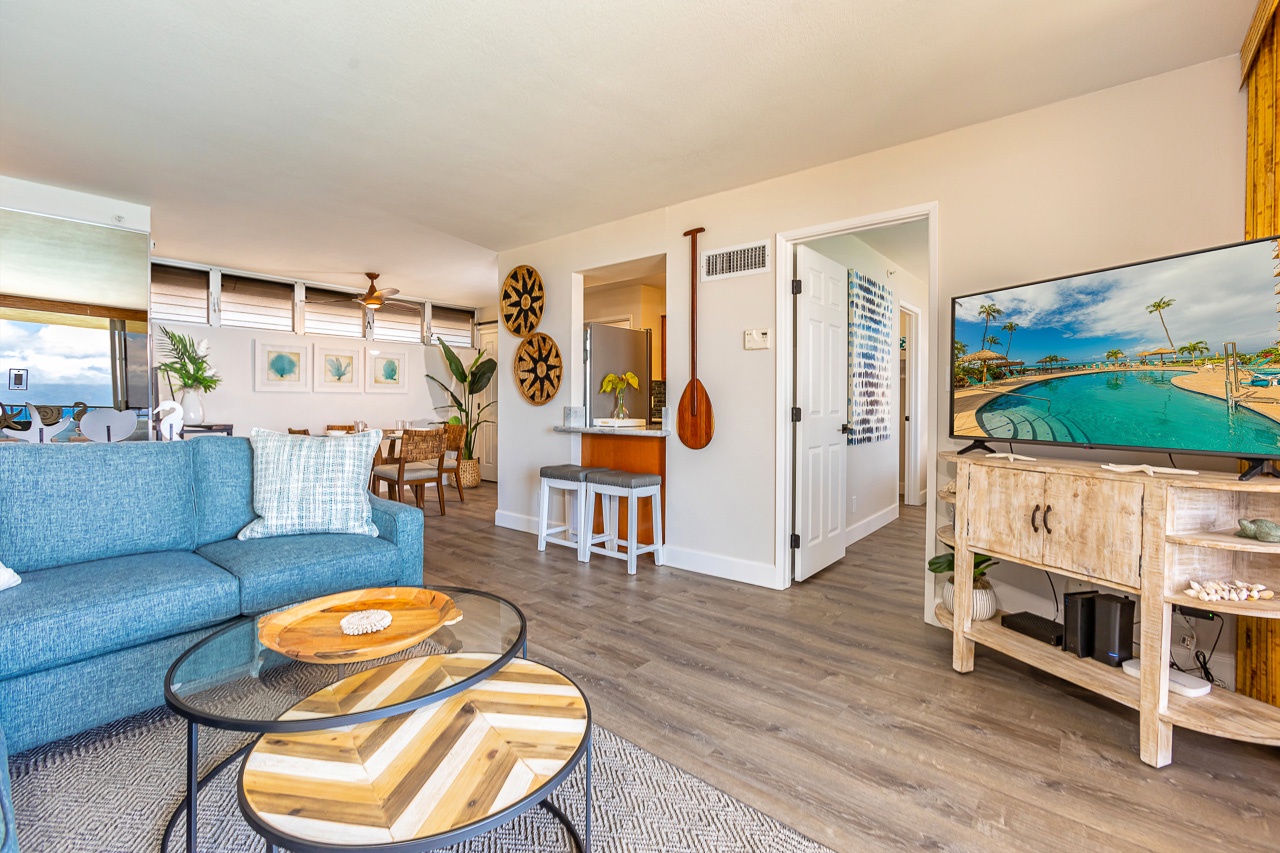 Settle into your bright, breezy living space where coastal charm meets comfort. Relax on the plush sofa, admire beach-inspired artwork, and enjoy open views that invite you to unwind completely.