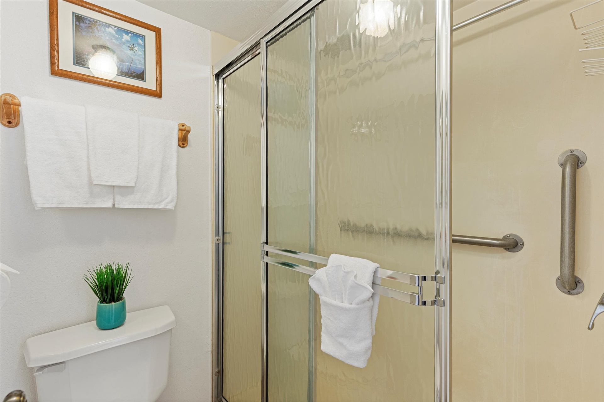 Your private bathroom features a spacious walk-in shower with thoughtful grab bars and fresh towels waiting for you, blending comfort with accessibility.