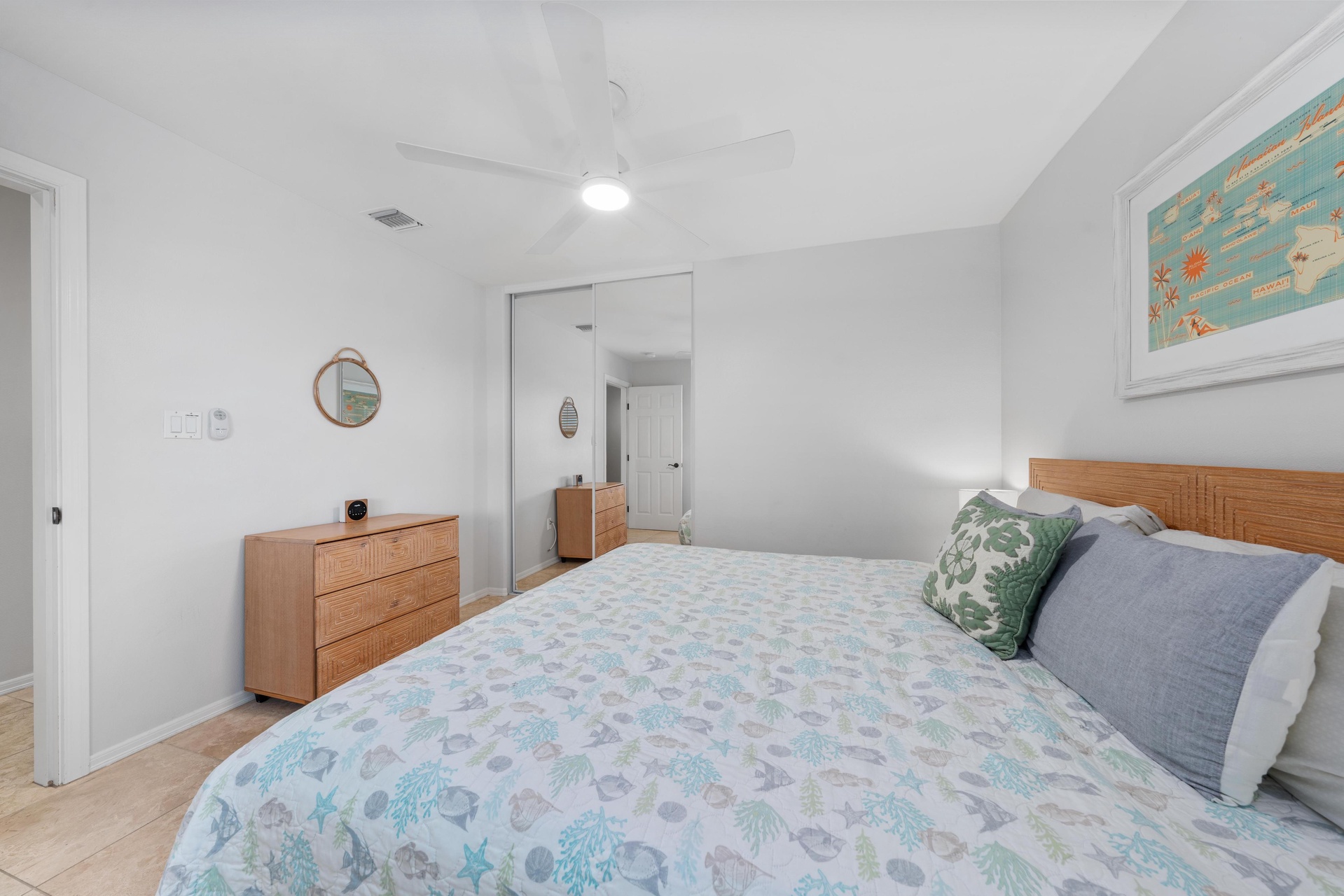 Rest peacefully in your serene bedroom featuring coastal-themed bedding, warm wood furnishings, and thoughtful touches that create the perfect retreat.
