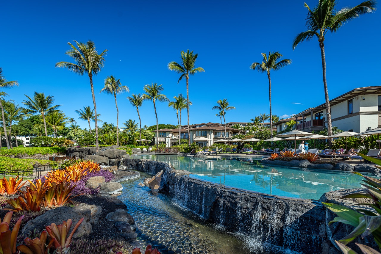 A tropical paradise nestled beneath swaying palms features a stunning multi-tiered pool framed by lava rock waterfalls and vibrant tropical gardens—your dream Hawaiian retreat awaits.