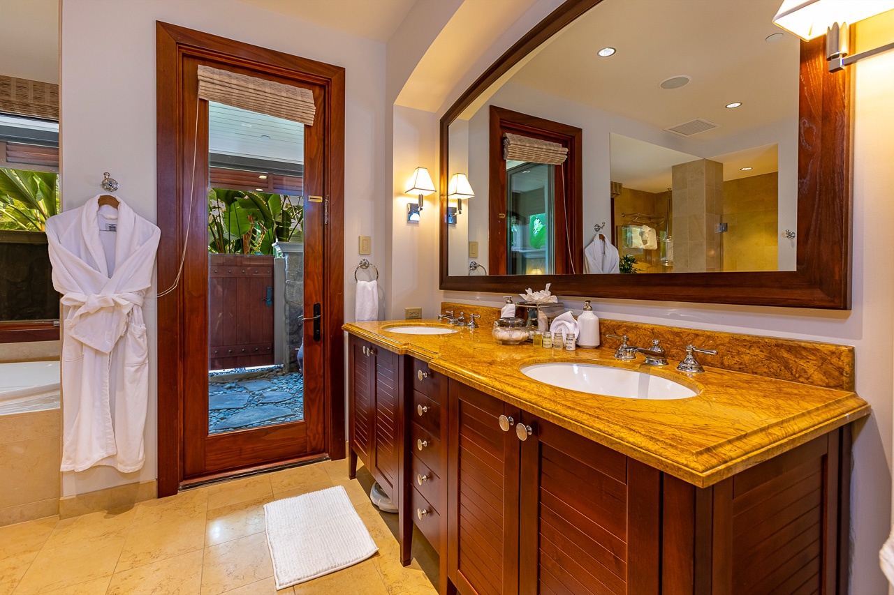 Step into your private spa-like bathroom with warm amber countertops and a plush robe waiting just for you. Fresh towels and tropical garden views make this your perfect retreat.