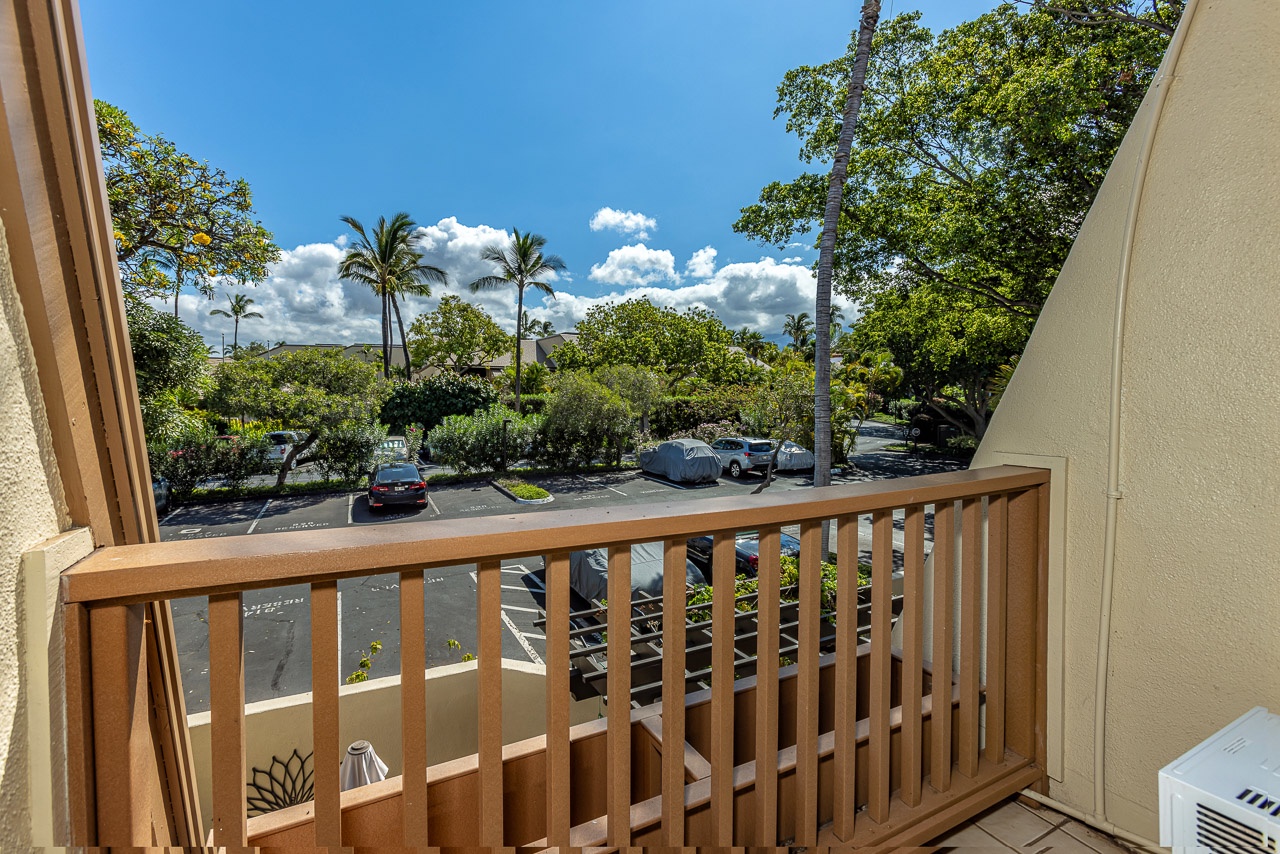 Your private balcony frames lush tropical trees and swaying palms under bright blue skies—perfect for morning coffee or simply soaking in the island atmosphere.