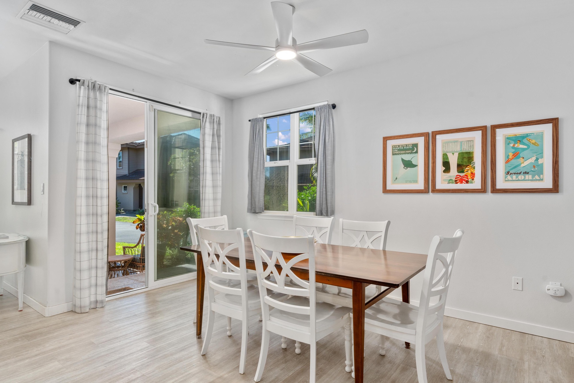 Your bright dining space features a welcoming table for six, ceiling fan for comfort, and garden access through sliding doors.
