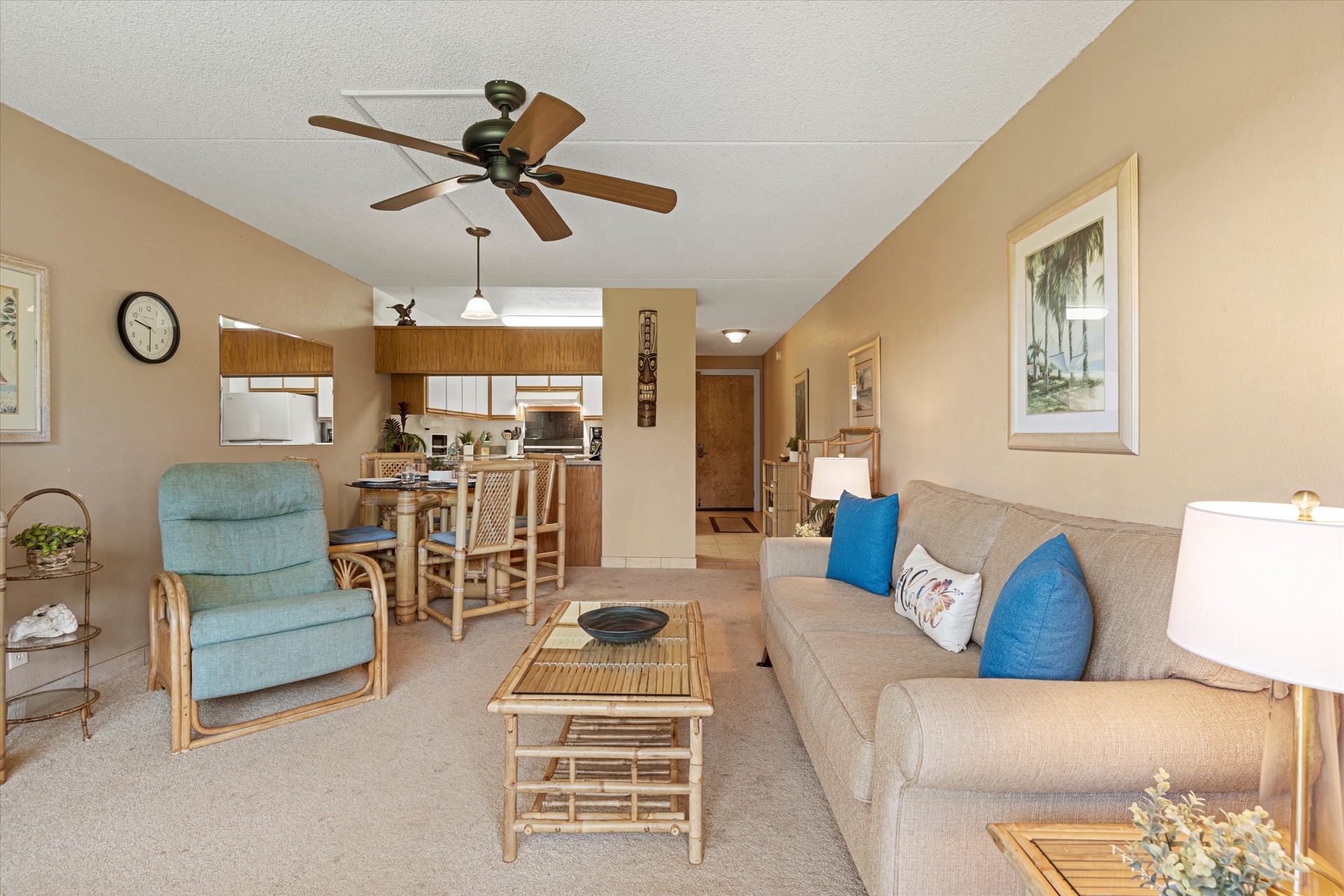 Your home away from home features an airy living room with beachy accents, cozy seating perfect for unwinding, and an open kitchen ready for preparing family meals together.