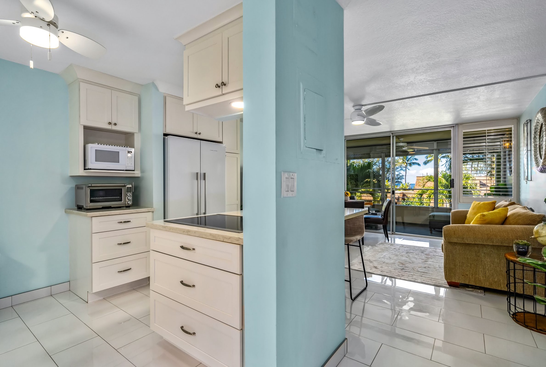 Your bright, beach-style condo seamlessly blends a fully equipped kitchen with a cozy living space, all bathed in natural light from the sunny patio just steps away.