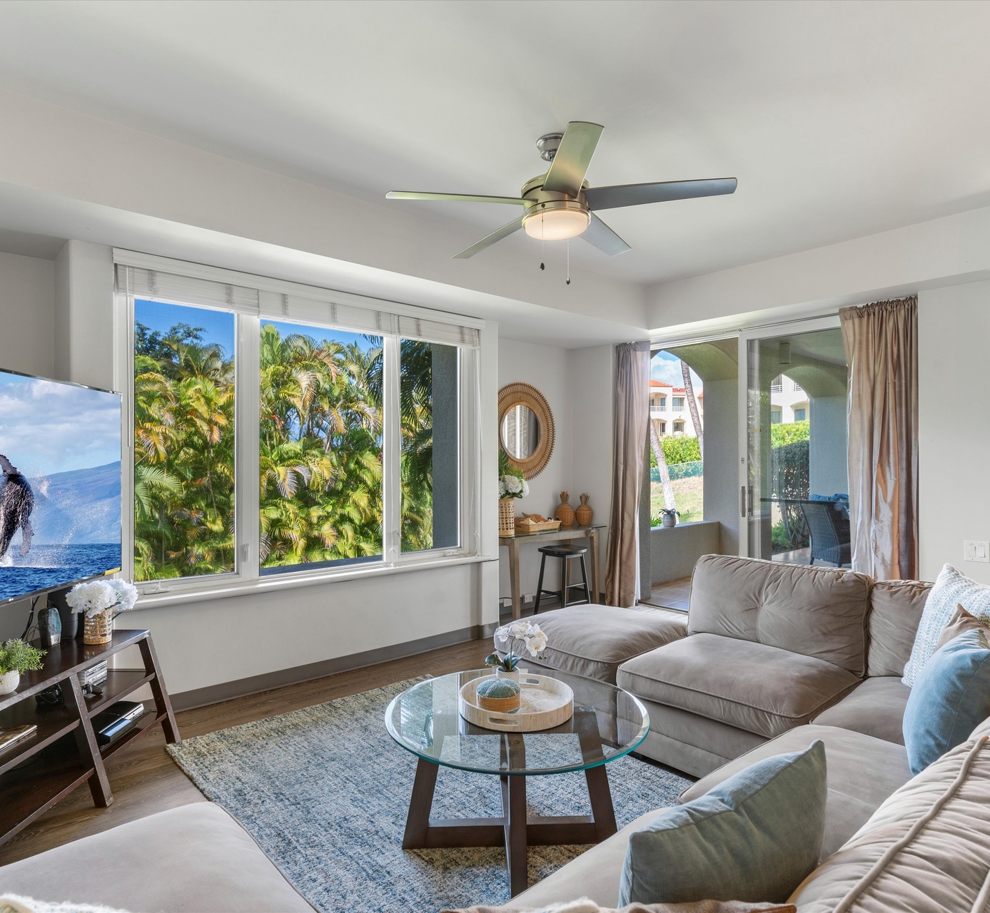 Relax in your bright living room with stunning tropical views and ocean glimpses through large windows.