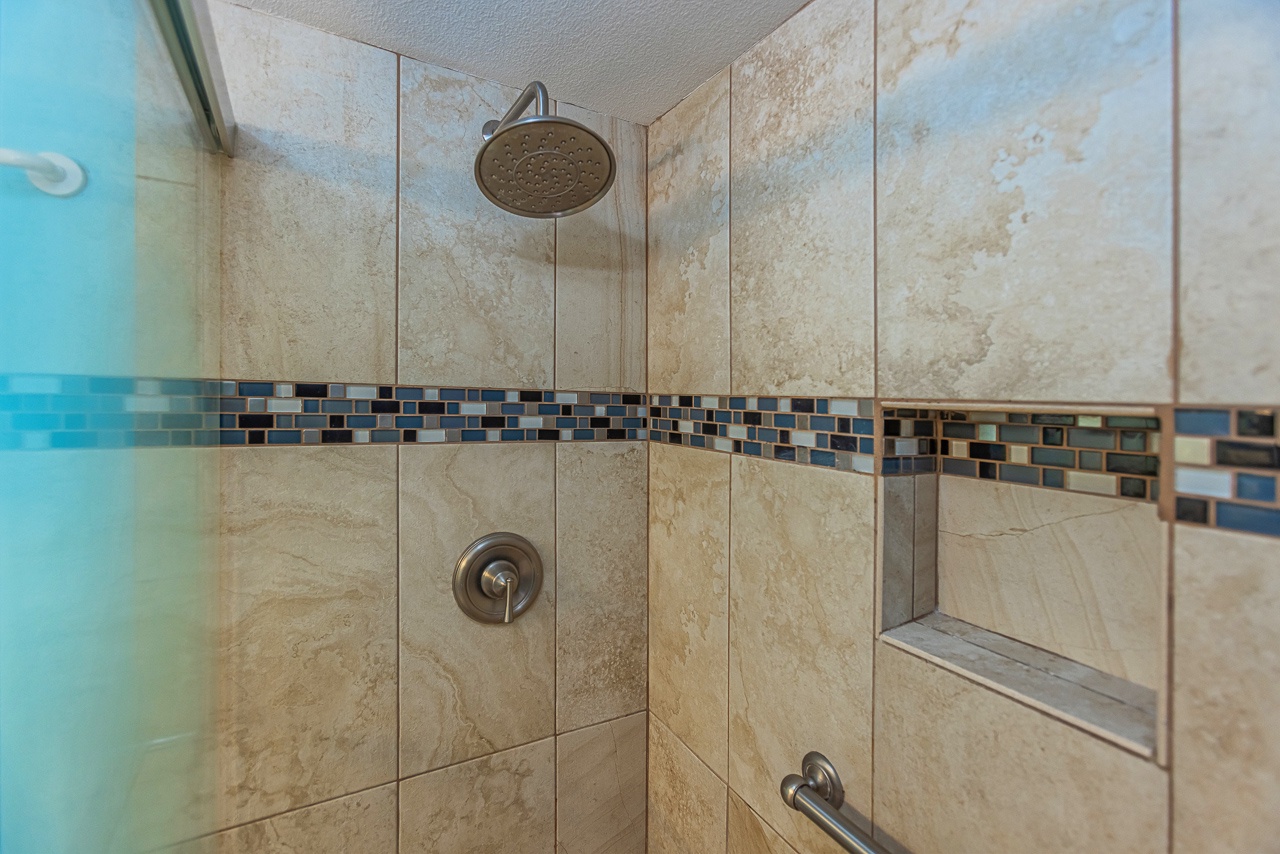 Rinse off in your beautifully tiled shower with a large rainfall head and mosaic accent band for a spa-like start to your day.
