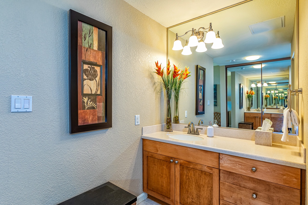 Step into your private bathroom, where warm lighting and a spacious vanity create the perfect space to start and end your day. Enjoy the thoughtful touches like fresh towels and a welcoming floral arrangement.