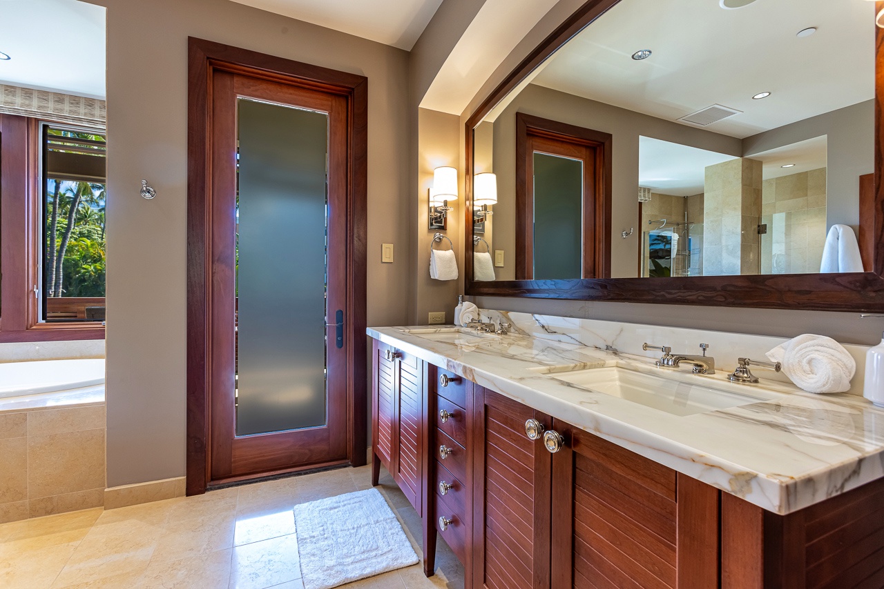 Your private bathroom sanctuary features a stunning marble double vanity and warm wood finishes, perfectly blending tropical luxury with modern comfort.