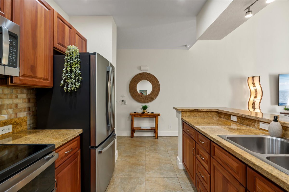 Your fully equipped kitchen features granite countertops, stainless steel appliances, and rich wood cabinetry—everything you need to prepare memorable meals during your stay.