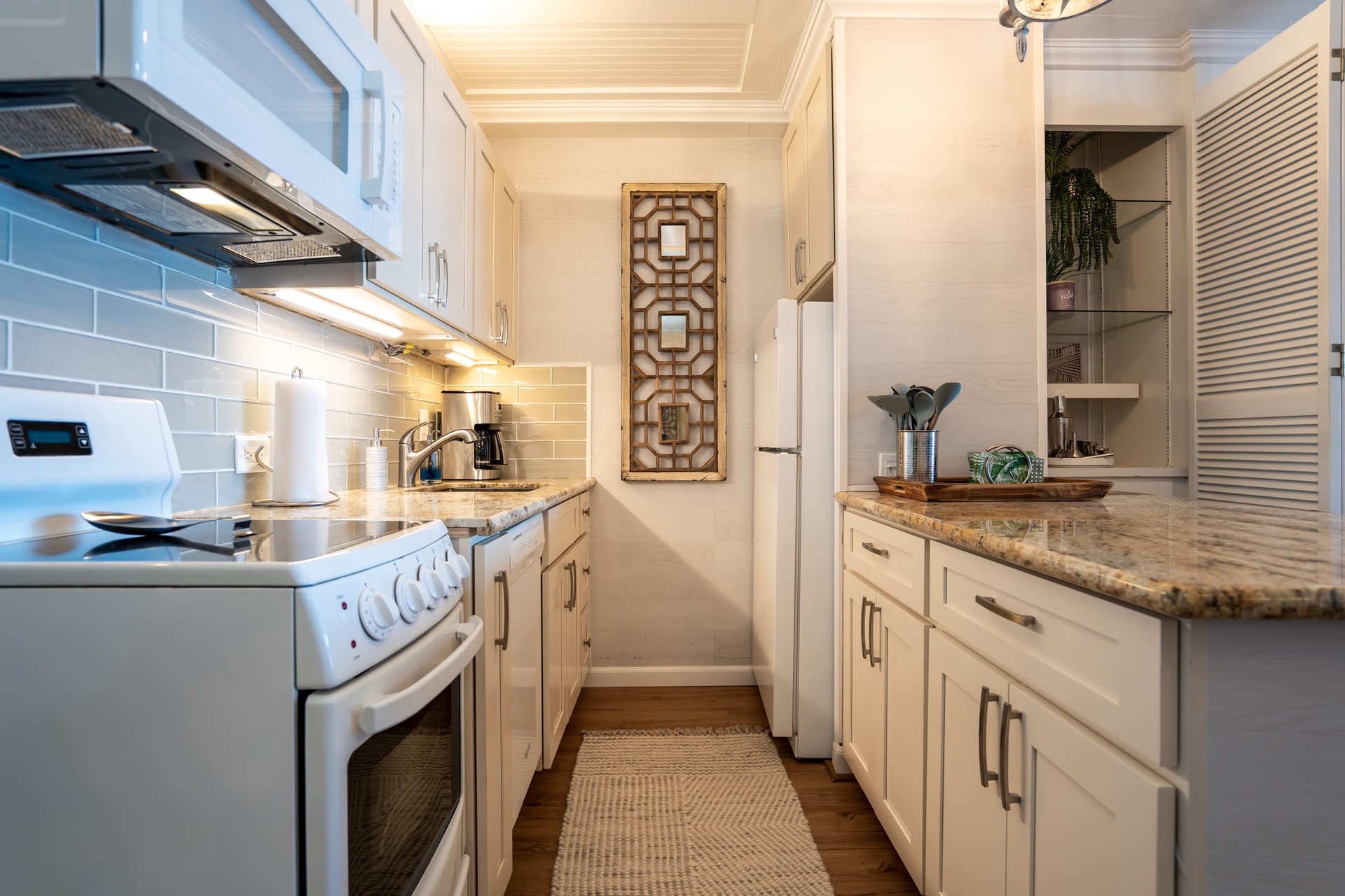 Your well-appointed galley kitchen features granite countertops, modern appliances, and coastal-inspired tile backsplash—everything you need to prepare meals in style during your stay.