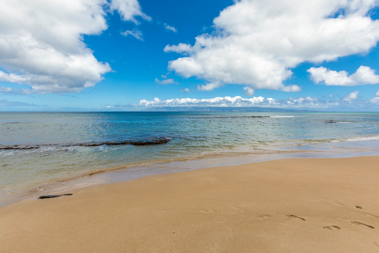 Pristine sandy beach with calm turquoise waters under a brilliant blue sky, offering a peaceful coastal escape in the property's surrounding area.