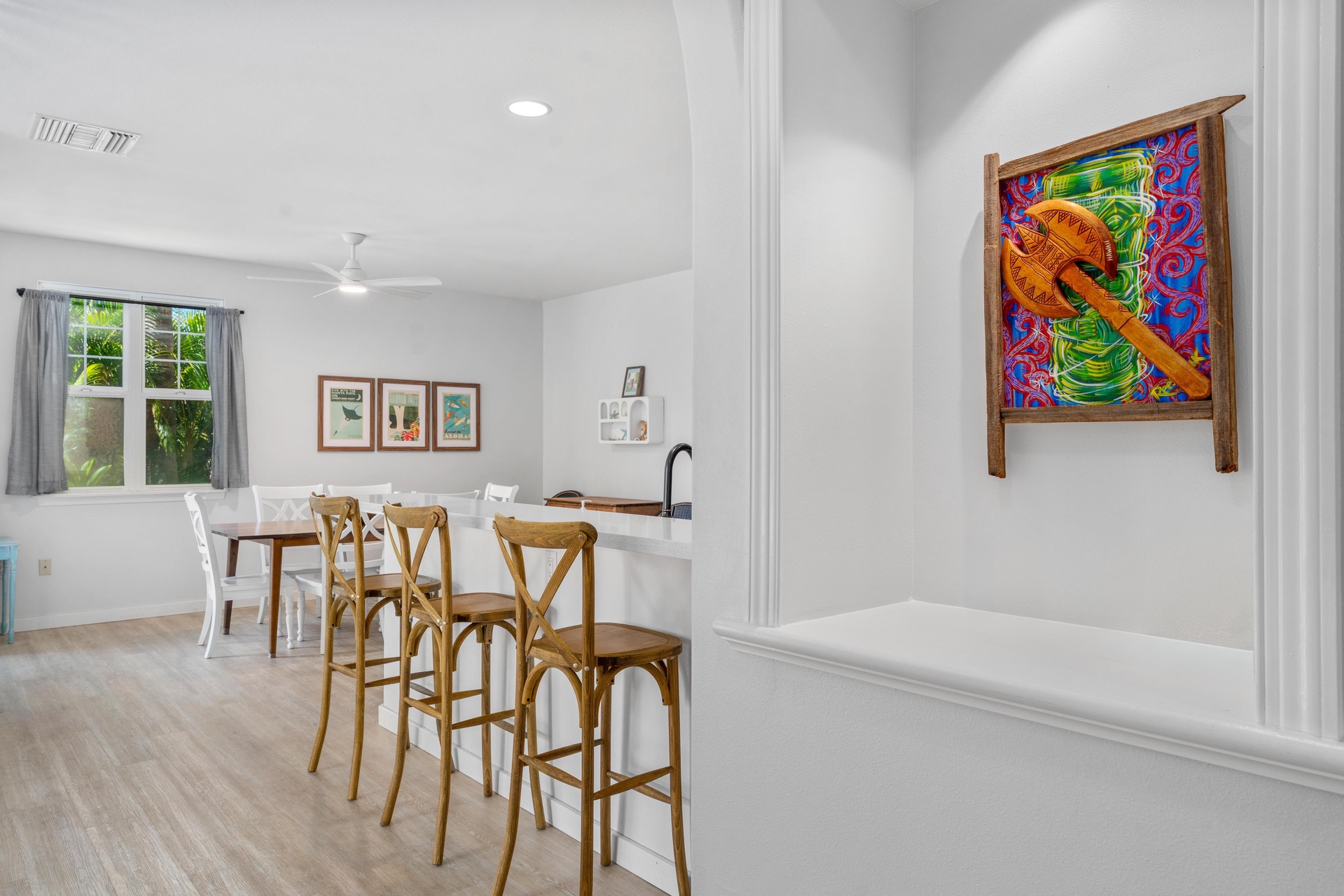 Gather around your bright kitchen island with friends, sharing meals in this airy space adorned with vibrant local artwork.