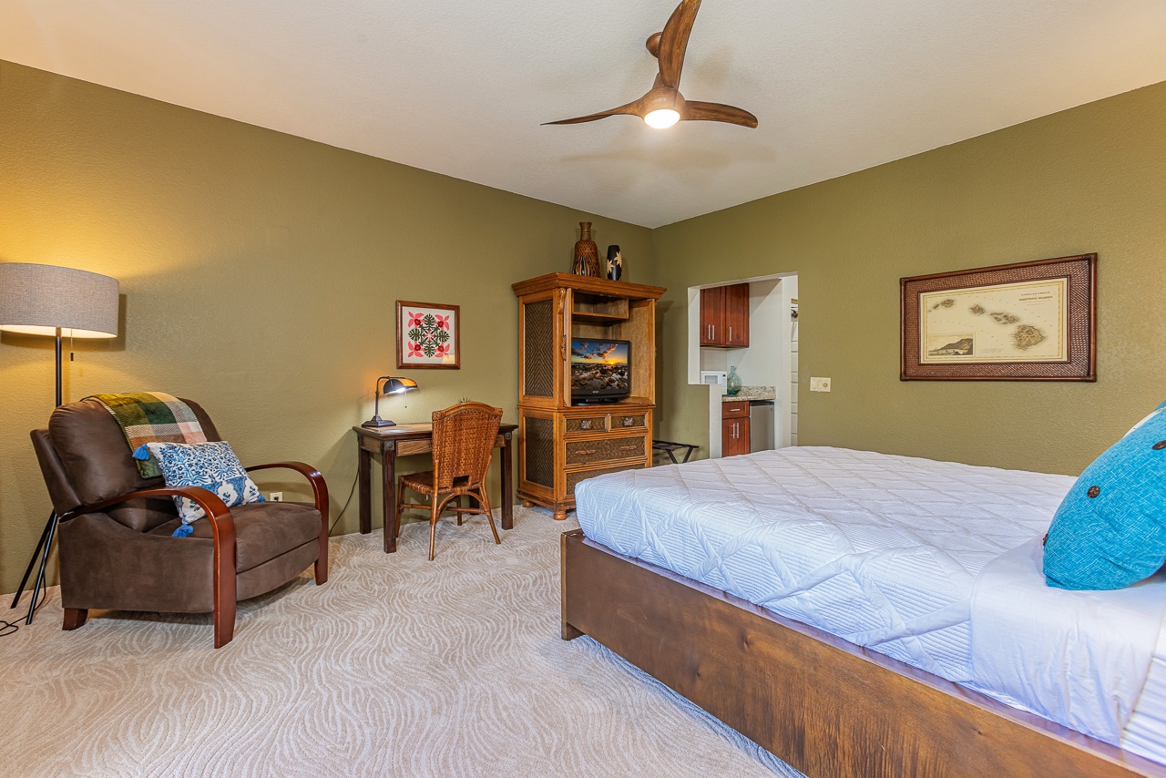 Spacious primary bedroom with king bed, desk, and smart tv